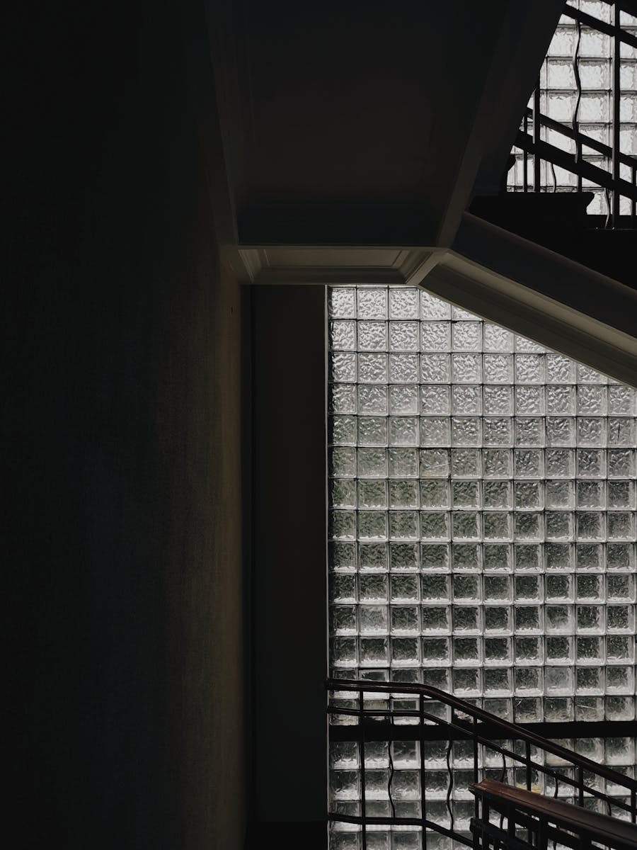 Dramatic staircase with industrial design and textured glass block windows.