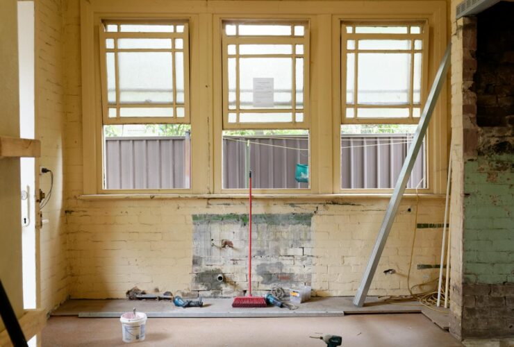 An empty room featuring large windows, ready for renovation in Sydney, Australia.