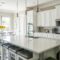 Spacious modern kitchen with white cabinets and island in natural light.