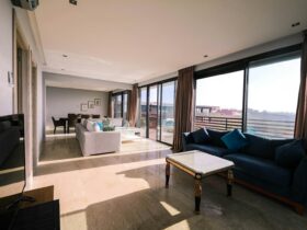 Bright and airy contemporary living room with furniture and large windows overlooking a city view.