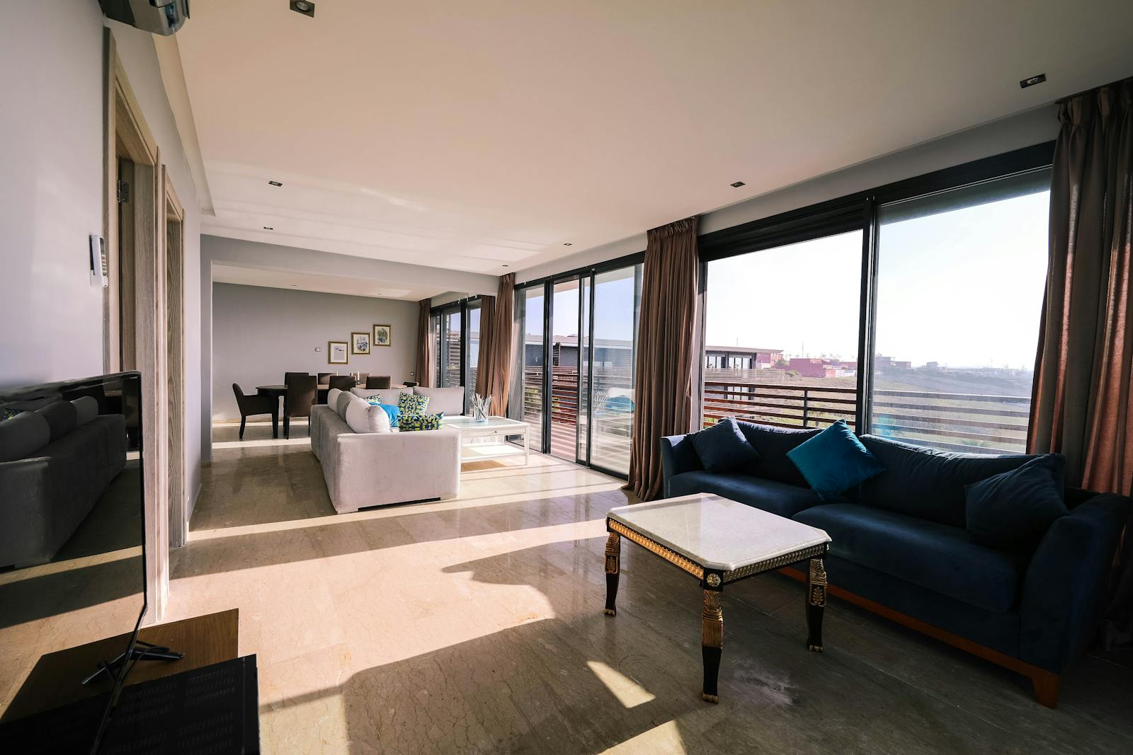 Bright and airy contemporary living room with furniture and large windows overlooking a city view.