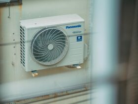 Air conditioner unit mounted outdoors on a building wall, showcasing modern HVAC technology.