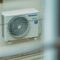 Air conditioner unit mounted outdoors on a building wall, showcasing modern HVAC technology.
