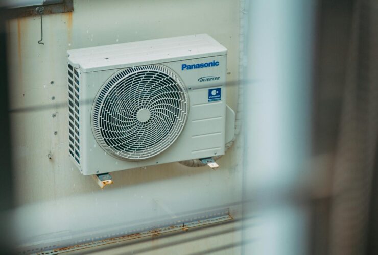 Air conditioner unit mounted outdoors on a building wall, showcasing modern HVAC technology.