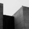 Minimalist black and white photo of brutalist concrete buildings with clean lines.