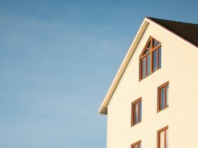 Minimalist modern residential building facade against clear blue sky.