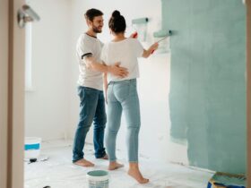 A couple painting a room together, focusing on home renovation and bonding.