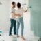 A couple painting a room together, focusing on home renovation and bonding.