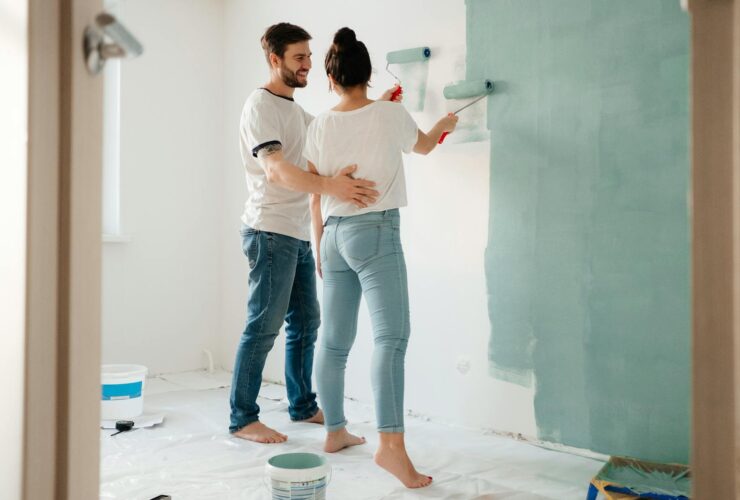 A couple painting a room together, focusing on home renovation and bonding.
