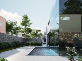 Elegant modern house with glass exterior and pool surrounded by lush greenery, under a clear sky.