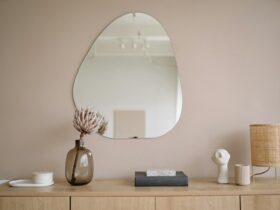 Stylish minimalist interior featuring a mirror, decorative vase, and lamp.