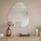 Stylish minimalist interior featuring a mirror, decorative vase, and lamp.
