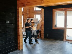 Two adults discussing home renovation in a partially constructed modern wooden interior.