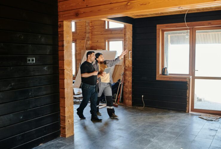 Two adults discussing home renovation in a partially constructed modern wooden interior.