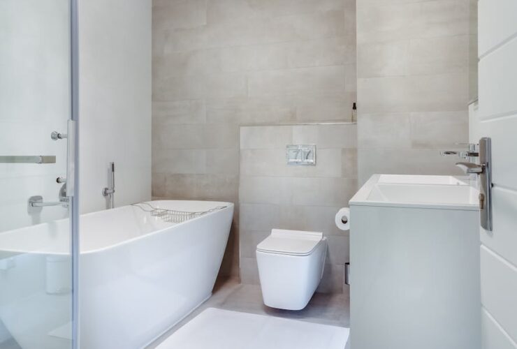 Elegant minimalistic bathroom featuring bathtub and sleek fixtures.
