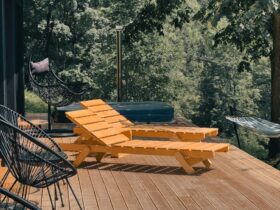 Wooden deck with lounge chairs surrounded by lush greenery, perfect for relaxation.