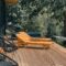 Wooden deck with lounge chairs surrounded by lush greenery, perfect for relaxation.