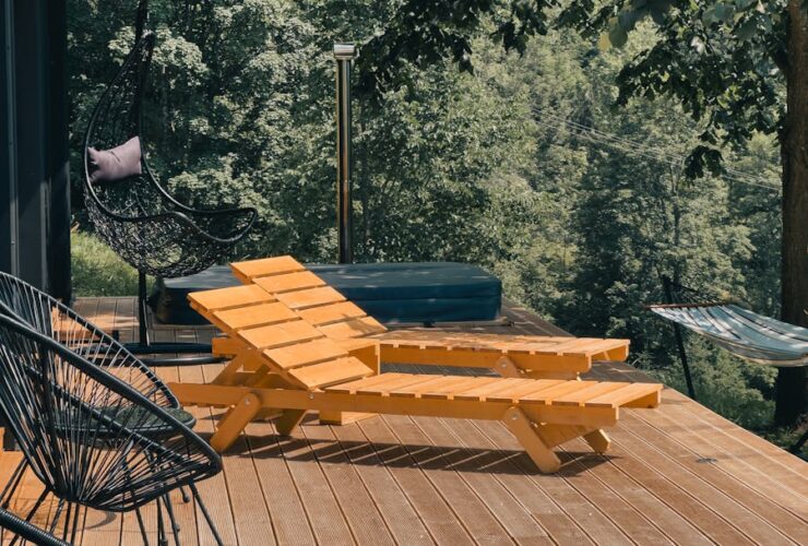 Wooden deck with lounge chairs surrounded by lush greenery, perfect for relaxation.