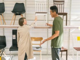 A couple explores chair options together in a modern furniture store during the day.