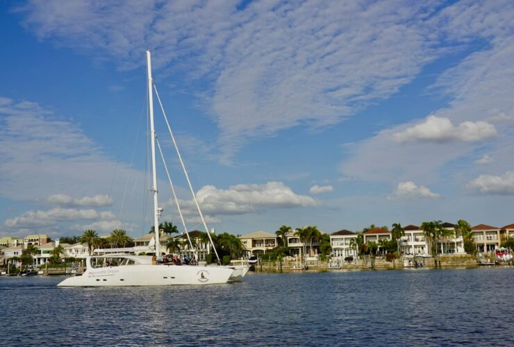 Yacht cruising in scenic Tampa Bay with waterfront homes and clear skies.