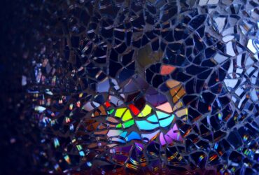 A colorful rainbow reflection through broken glass, creating an artistic and abstract effect.