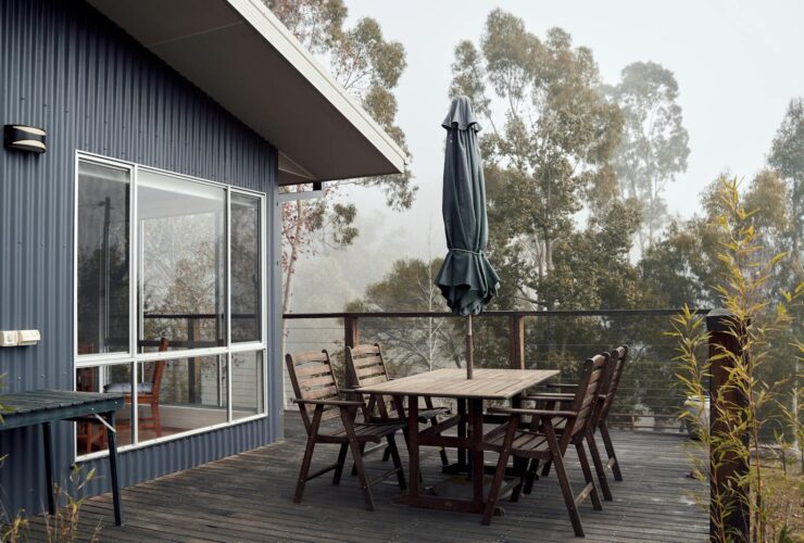 A serene outdoor terrace with wooden furniture on a foggy day, ideal for tranquility.