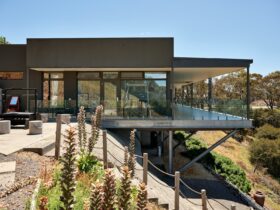 A modern house with a glass balcony overlooking the mountains