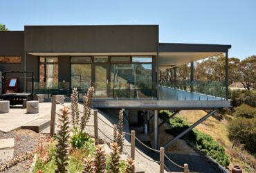 A modern house with a glass balcony overlooking the mountains