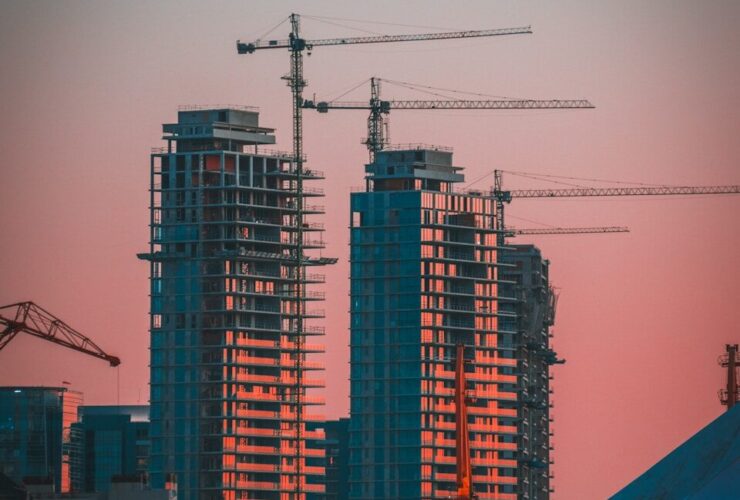 gray building crane photo during sunset