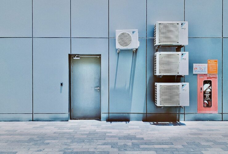 a couple of air conditioners sitting on the side of a building