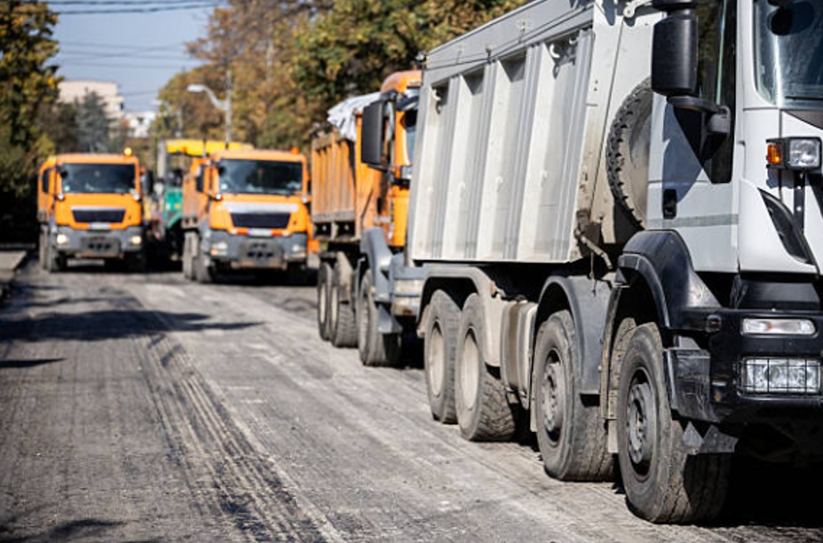 A Fleet Of Trucks On A Dirty Road. Construction Site Compliance