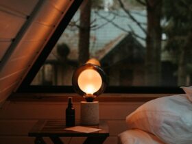 a bed sitting under a window next to a night stand
