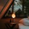 a bed sitting under a window next to a night stand