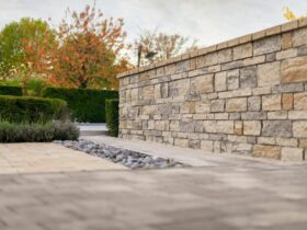 Stone wall with autumn trees and manicured hedges