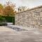 Stone wall with autumn trees and manicured hedges