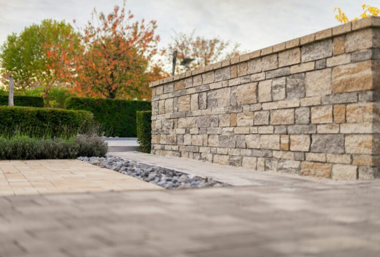 Stone wall with autumn trees and manicured hedges