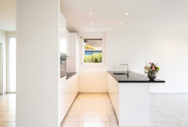 white ceramic bathtub near white wall