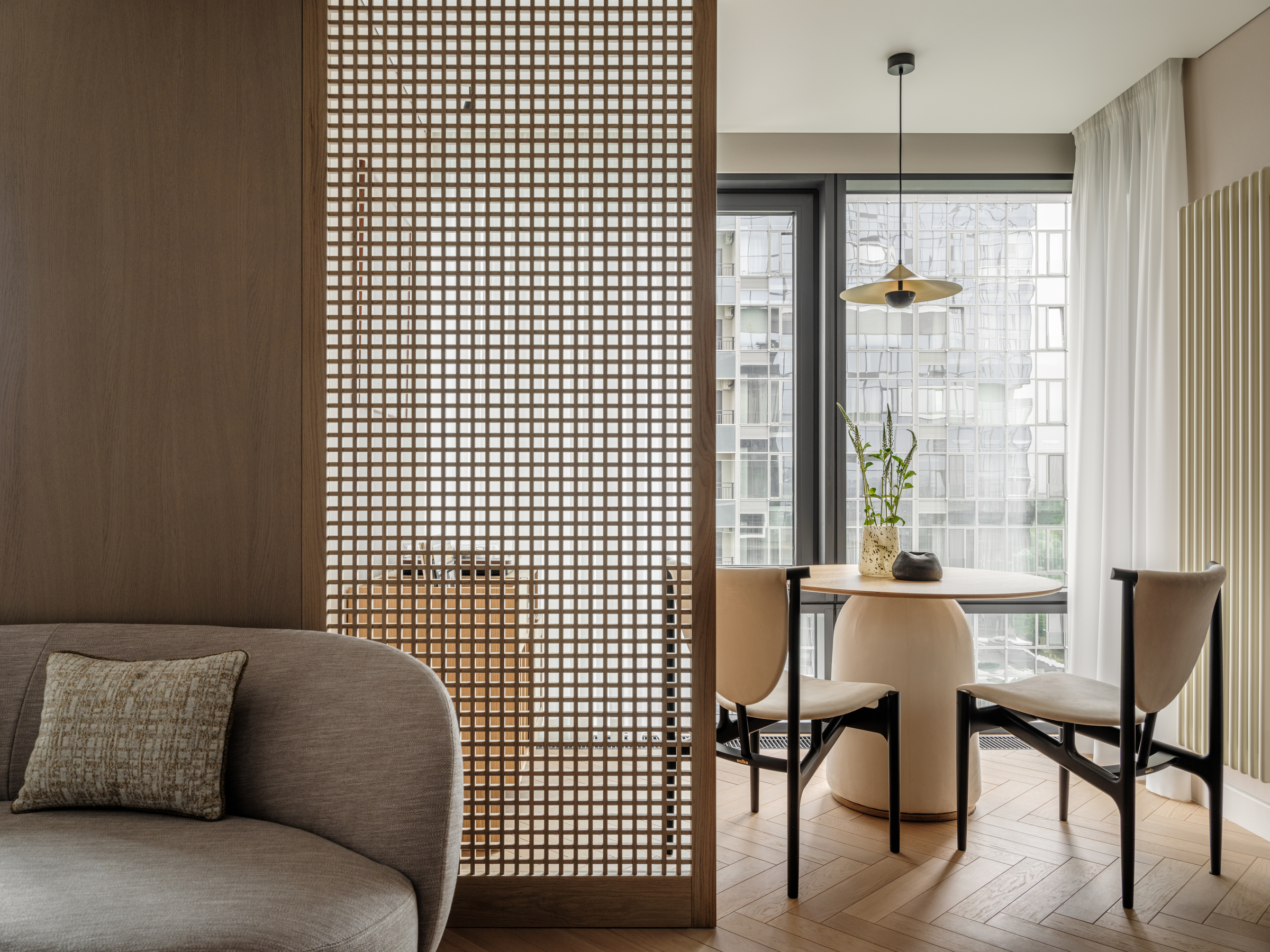 living and dining areas separated by wooden lattice screen