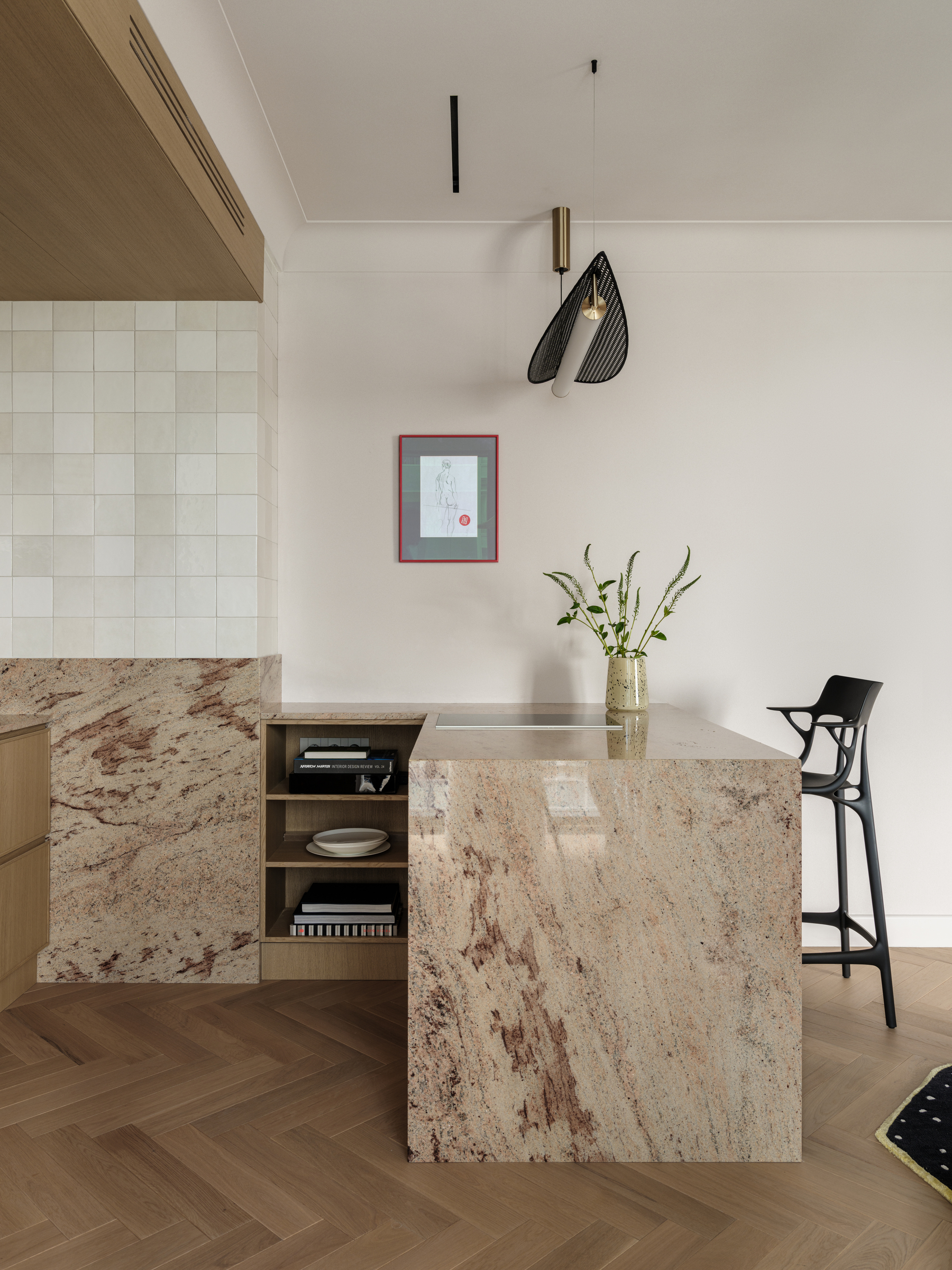 kitchen island with granite surfaces and black sculptural bar stools