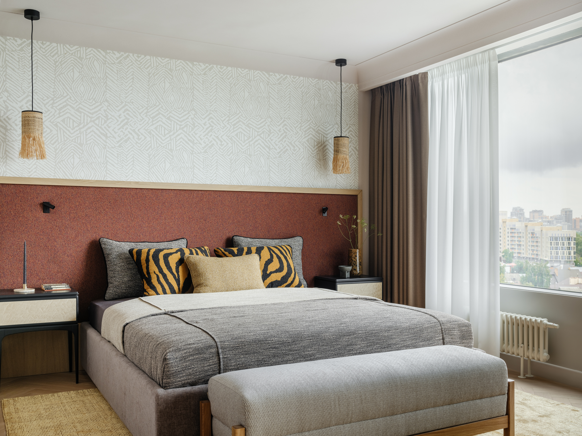 bedroom with terracotta headboard wall and patterned white wallpaper