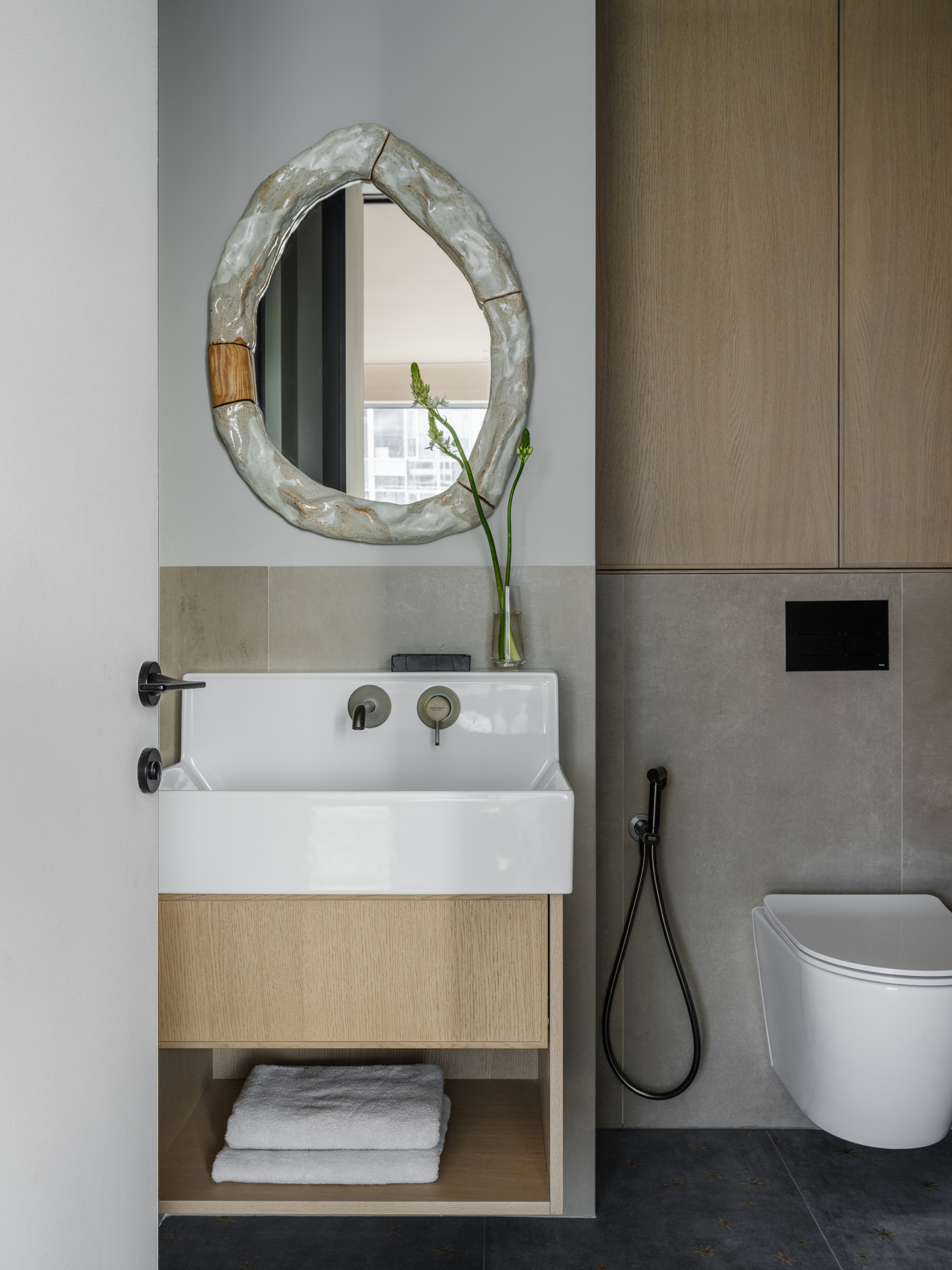 bathroom vanity with organic ceramic mirror and oak cabinetry