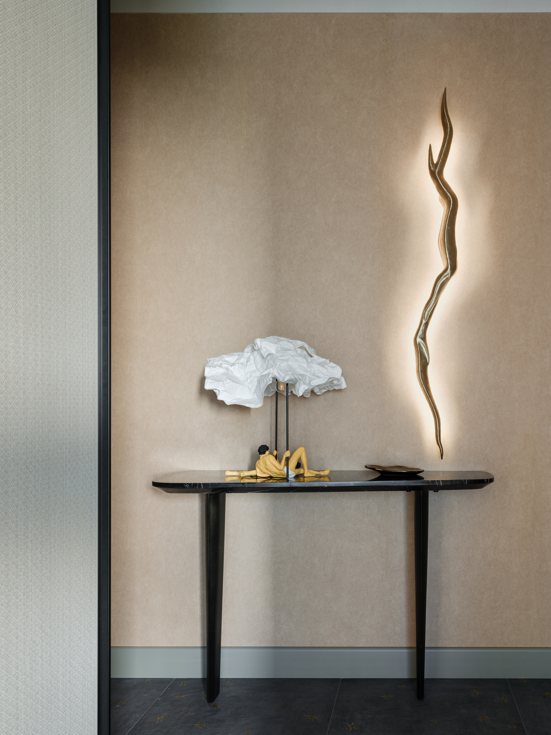 hallway console table with paper flower lamp and nude figurine on dusty blue tiles
