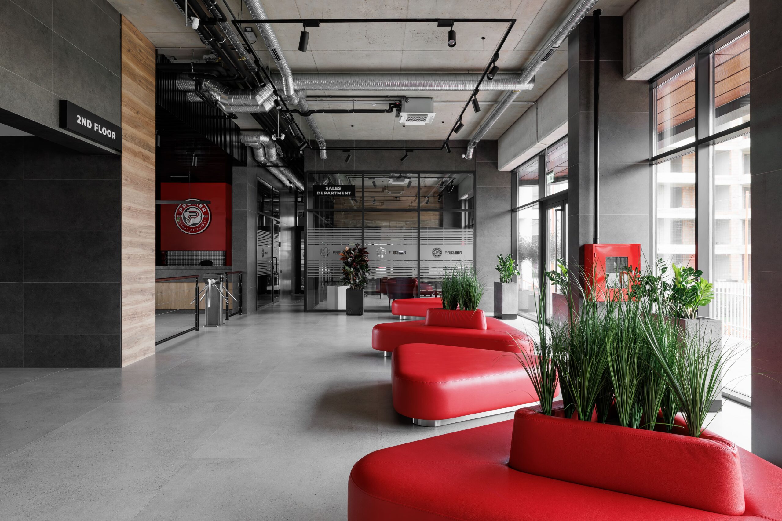 Interior lobby with red curved seating and exposed industrial ceiling ducts