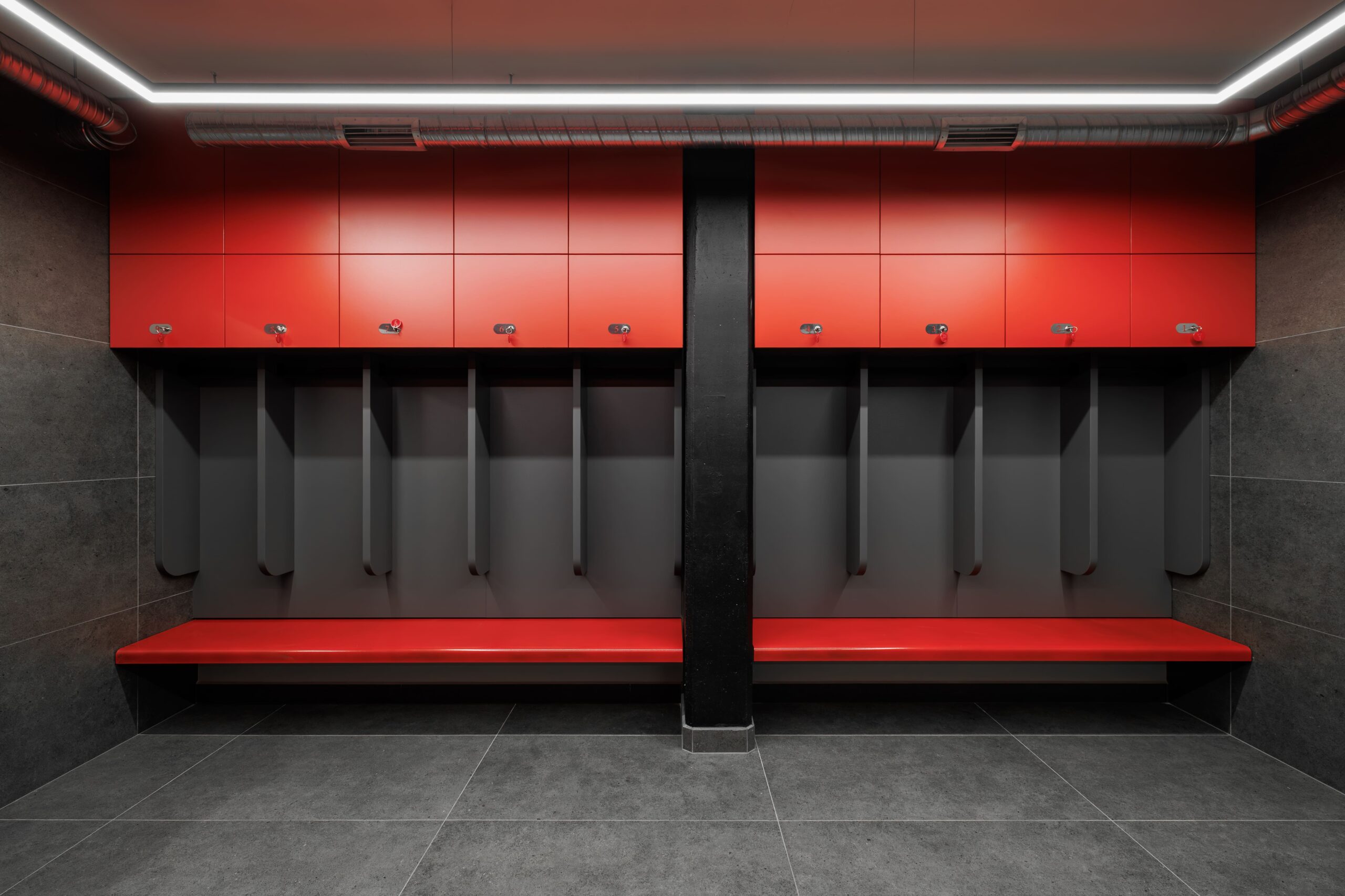 Team locker room with red overhead cabinets and LED strip lighting