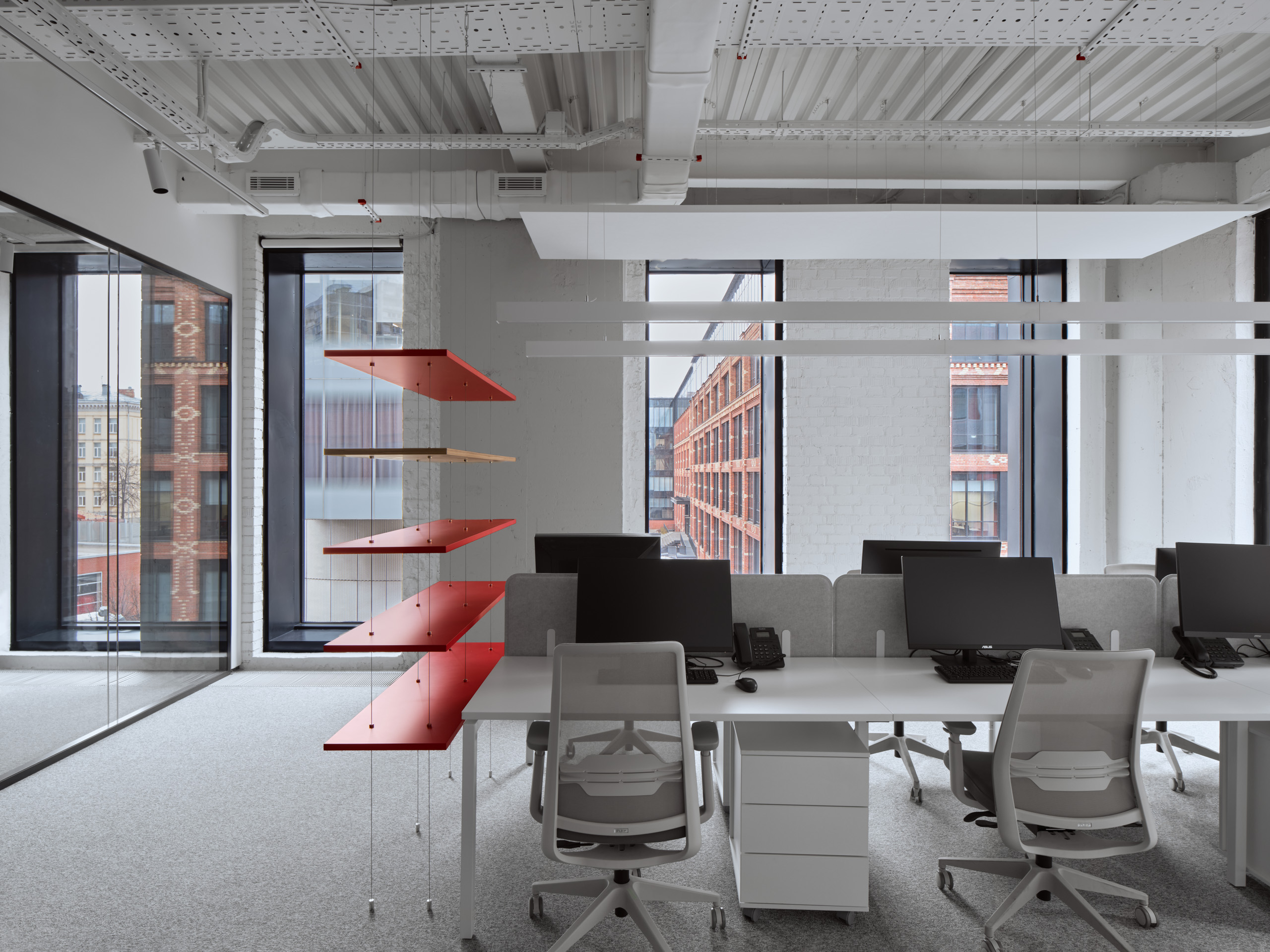 DKC office Moscow workspace with red pendant lights and mirrored partition walls
