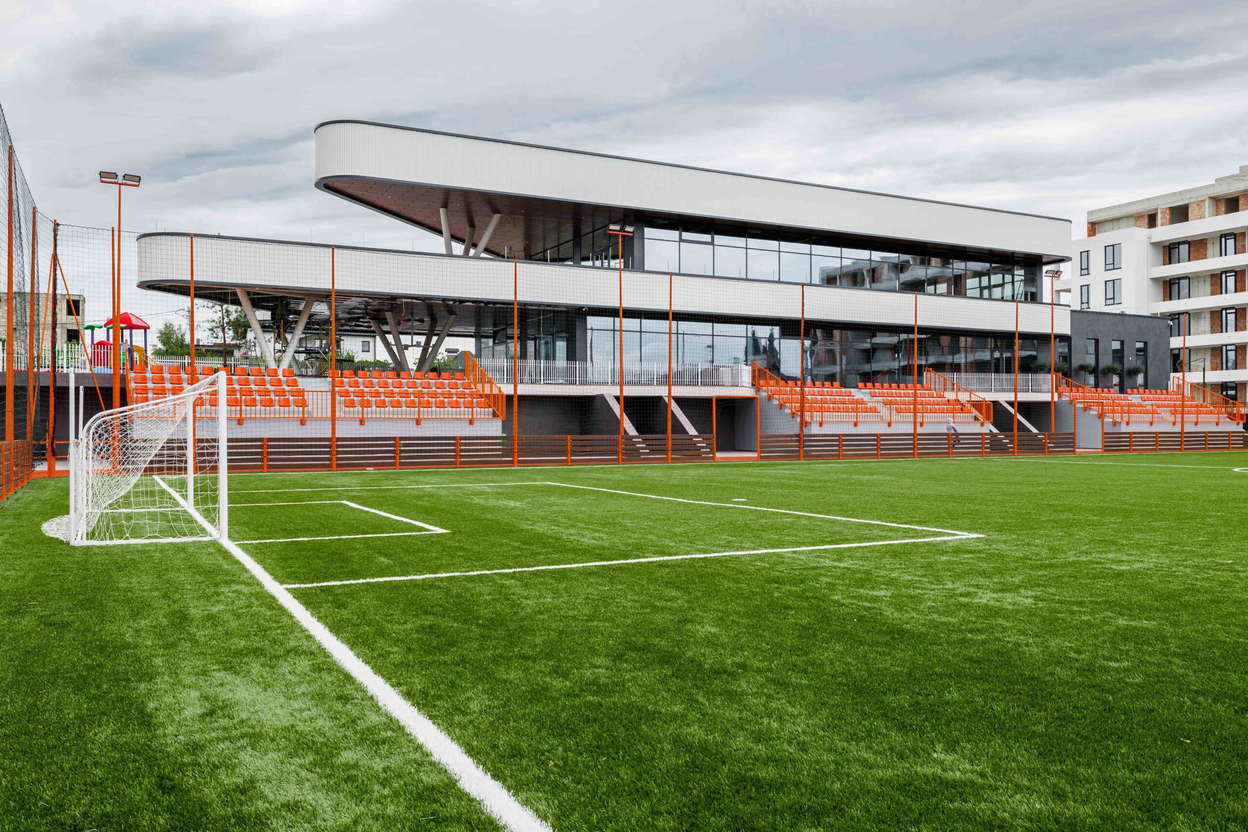 Soccer field view with building behind orange bleachers