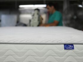 a man is working on a mattress in a warehouse