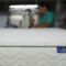 a man is working on a mattress in a warehouse