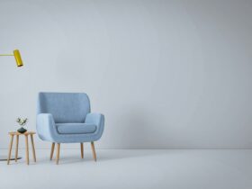 a blue chair and a yellow lamp in a white room