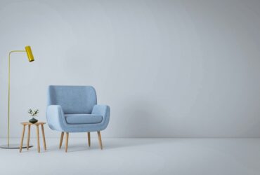 a blue chair and a yellow lamp in a white room